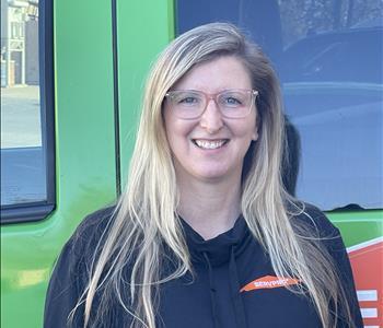 Our Accounting & HR Administrator, Holly Kane, standing in front of one of our SERVPRO vehicles.